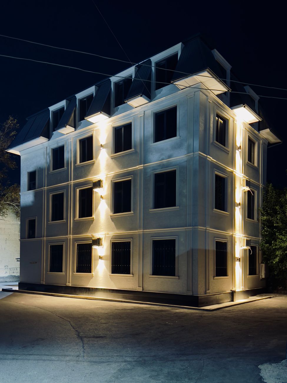 A beautifully lit facade of a modern building at night in Kokand city · Fergana Valley, Uzbekistan