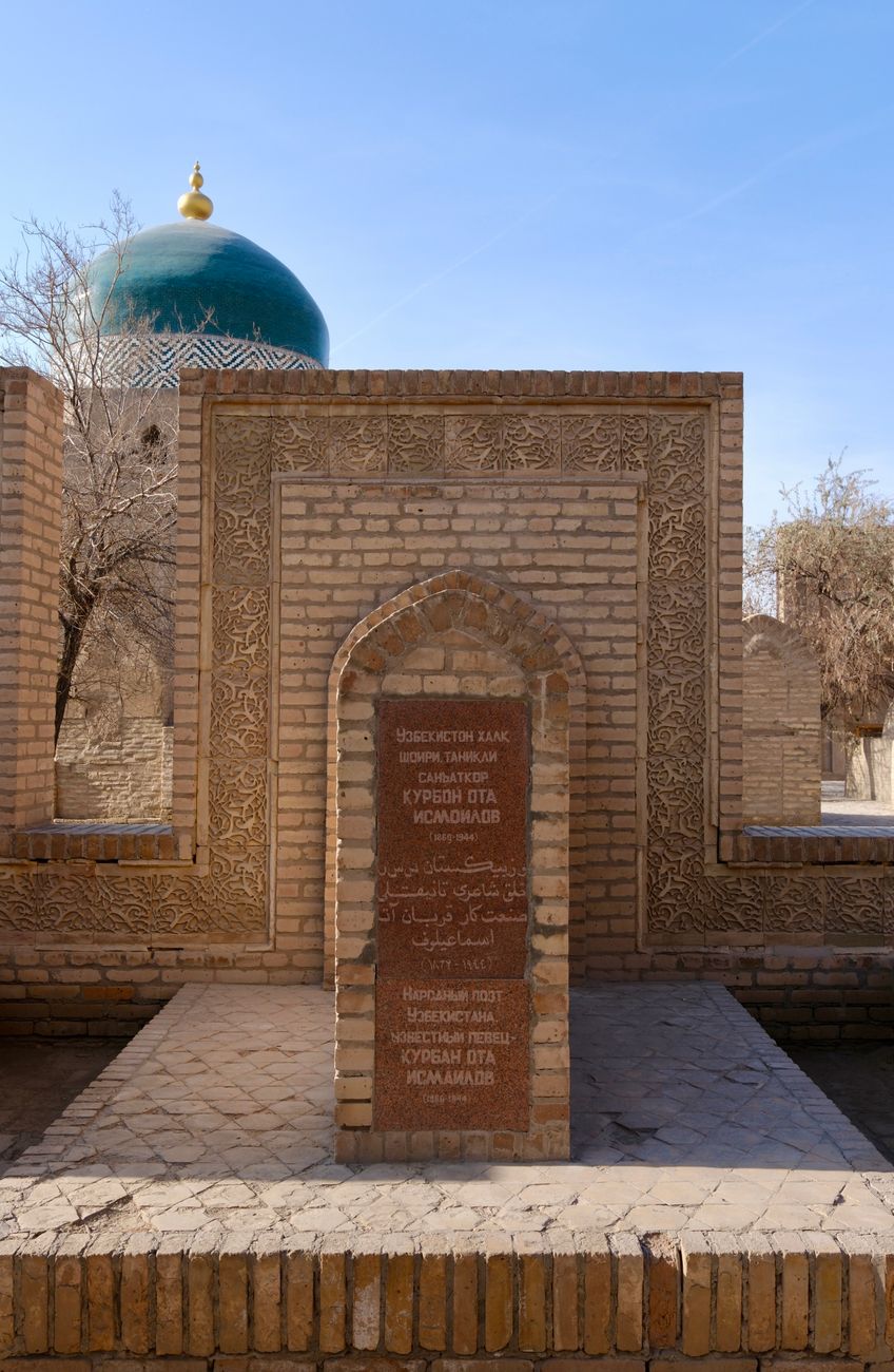 A historic brick archway with a green dome in a sunlit ancient complex · Muynak & the Aral Sea, Uzbekistan