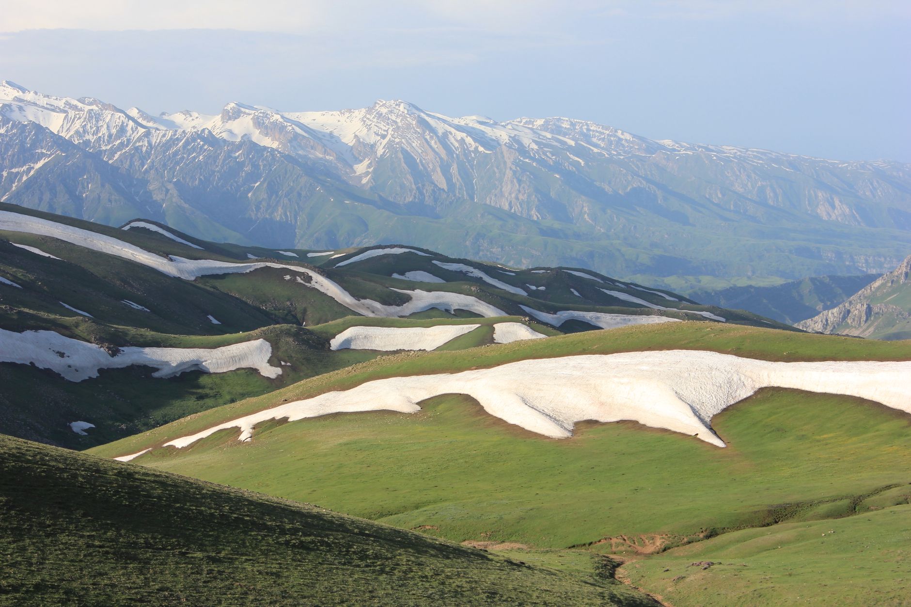 Snow-capped mountains and green hills under a clear sky · Chimgan & Charvak, Uzbekistan