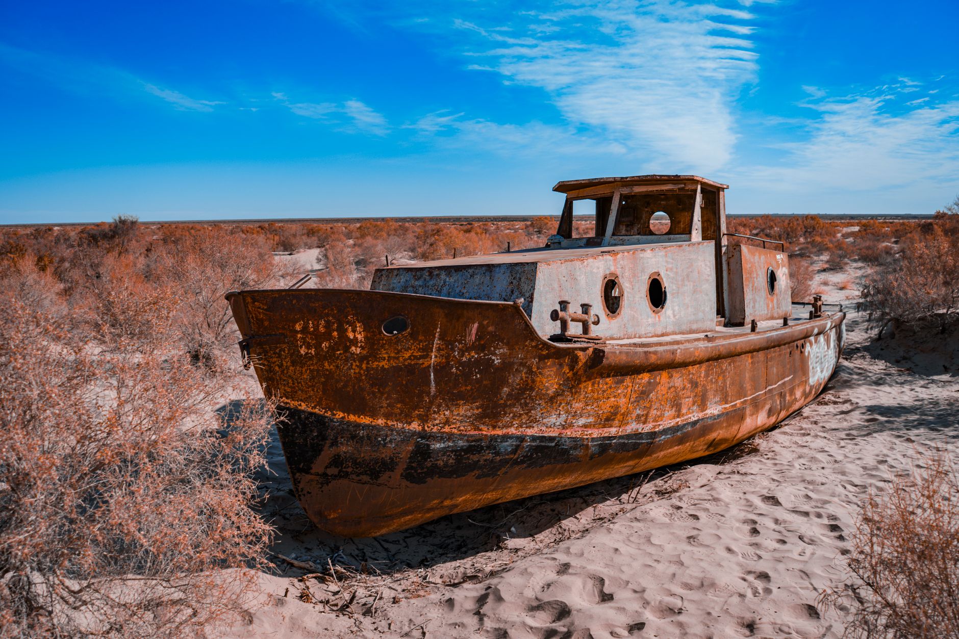 Abandoned rusty ship stranded on the sandy desert where the Aral Sea once existed in Uzbekistan · Muynak & the Aral Sea, Uzbekistan
