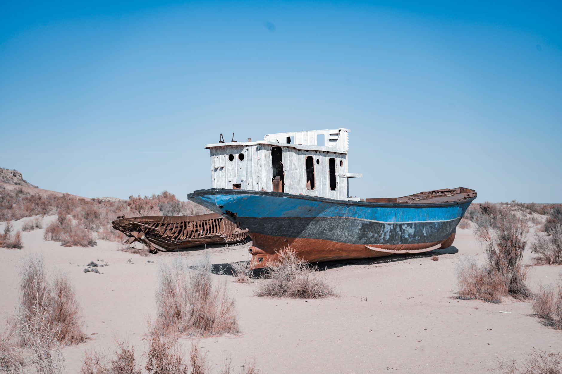 Rusty abandoned ships stranded on the Aral Sea desert, highlighting environmental disaster effects · Muynak & the Aral Sea, Uzbekistan