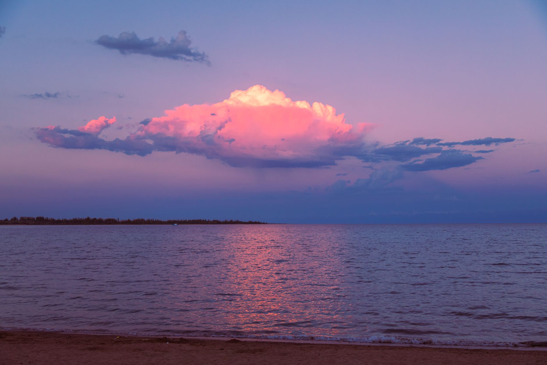 Sunset over Issykul Lake with colorful clouds and serene waters in Uzbekistan · Nurata & Aydarkul, Uzbekistan