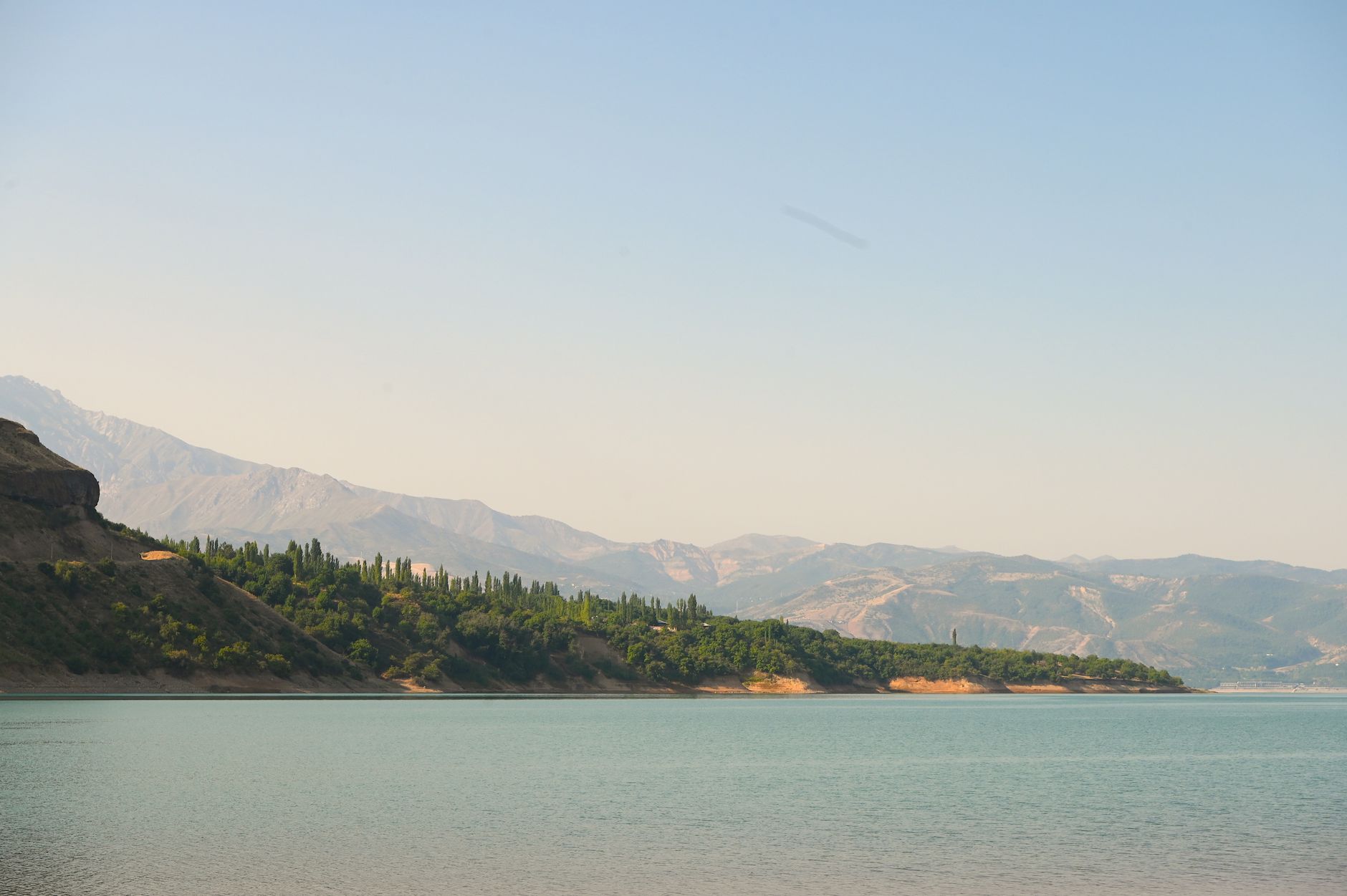 View of a mountain lake surrounded by lush green hills in Tashkent Region, Uzbekistan · Nurata & Aydarkul, Uzbekistan