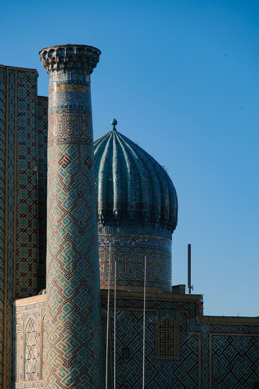 View of a historic minaret and dome at sunrise in Samarkand, Uzbekistan