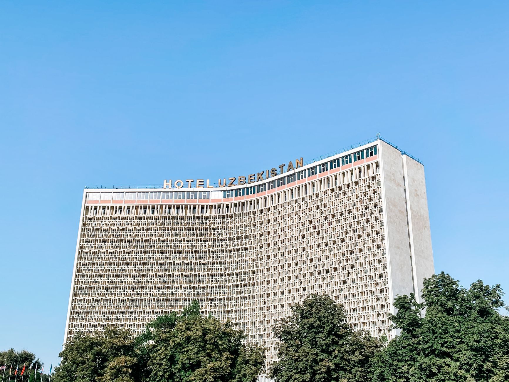 A striking view of the Hotel Uzbekistan facade under a clear blue sky · Tashkent, Uzbekistan