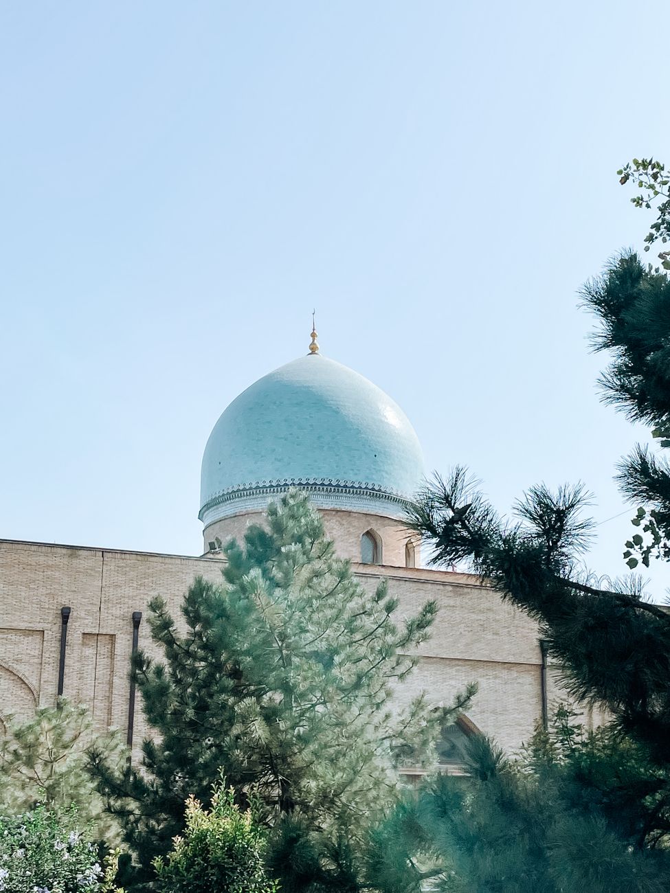 View of a mosque with a blue dome amid lush greenery in Tashkent, Uzbekistan